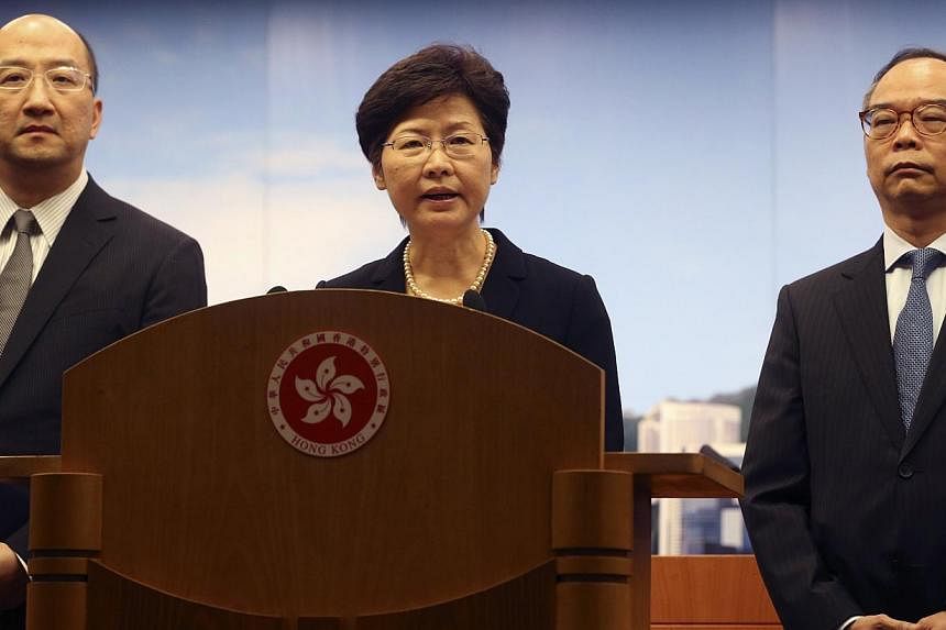 Hong Kong's acting chief executive Carrie Lam (centre) on Tuesday called on pro-democracy protesters to clear sites they have occupied in the Asian financial centre for more than six weeks and warned that those who remained could face arrest. -- PHOT