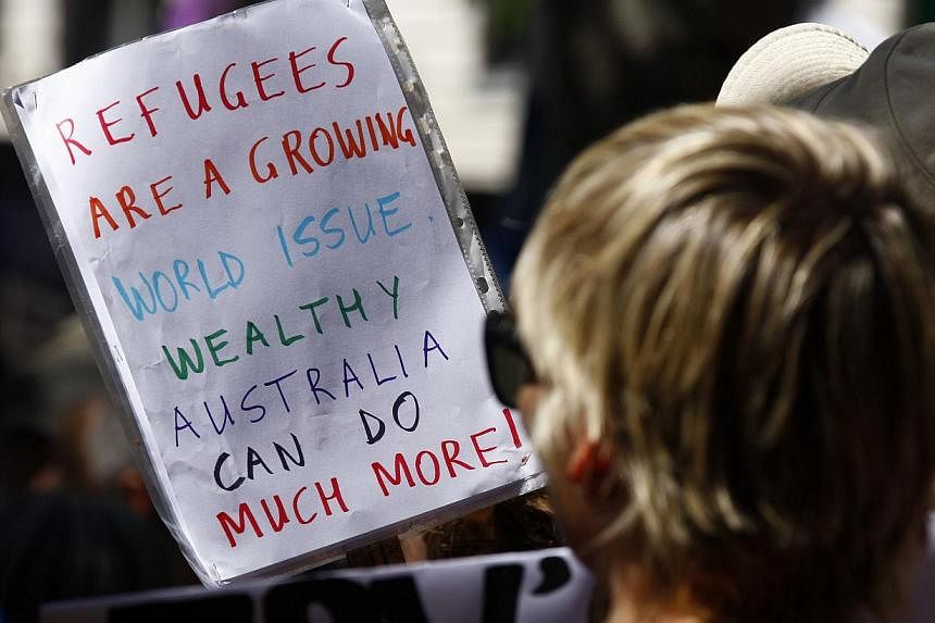Protesters hold placards at the 'Stand up for Refugees' rally held in central Sydney on Oct 11, 2014. Around a thousand protesters attended the rally, demanding changes to the Australian government's current policies for refugees. -- PHOTO: REUTERS