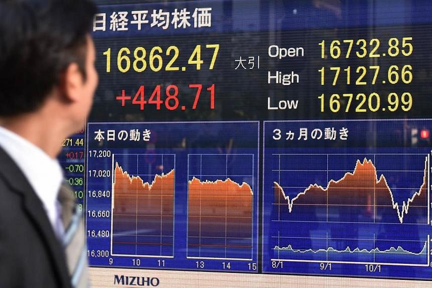 Asian markets mostly rose Tuesday after US shares tapped fresh records for a fourth straight session, while a weaker yen helped Japan's Nikkei extend its recent rally. -- PHOTO: AFP