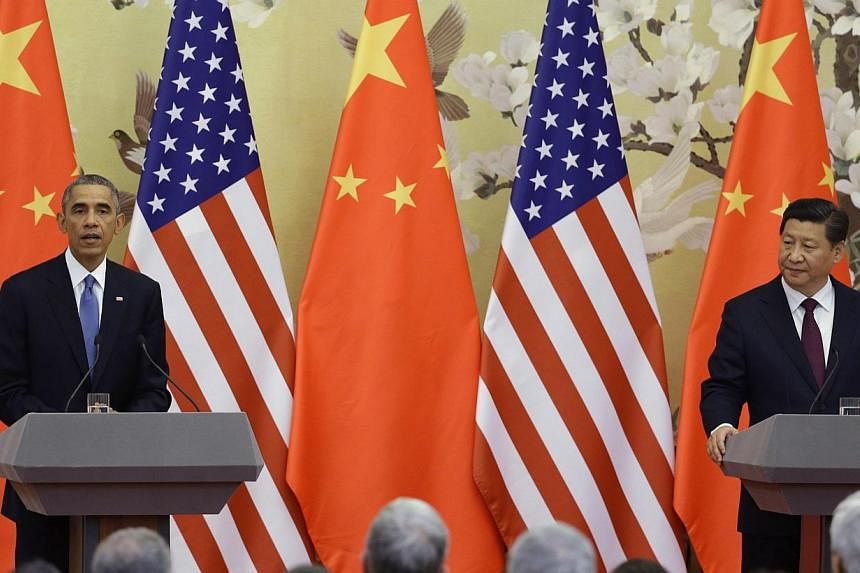 U.S. President Barack Obama (left) speaks to the media in front of U.S. and Chinese national flags during a joint news conference with China's President Xi Jinping (right) at the Great Hall of the People in Beijing on Nov 12, 2014. -- PHOTO: REUTERS&