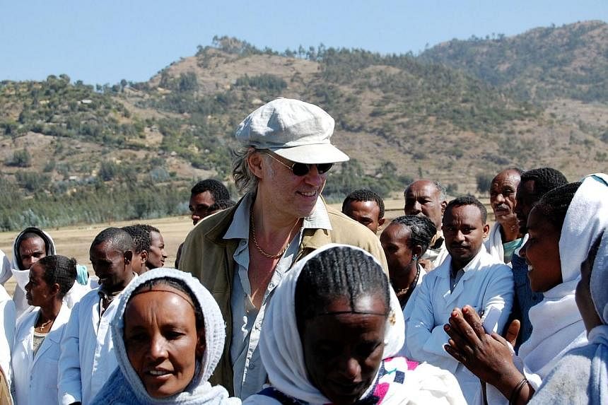 Irish founder of the Band-aid charity Bob Geldof (centre) with local people during a visit to Korem in Ethiopia&nbsp;on Nov 25, 2009.&nbsp;A new group of stars coming together to record a new version of Do They Know It's Christmas this year to raise 