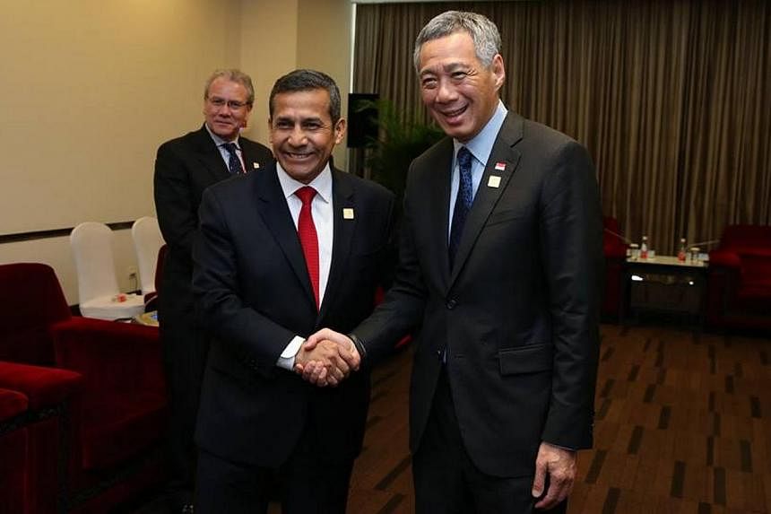 PM Lee shakes hands with Peruvian President Ollanta Humala at the 2014 Apec economic leaders’ meeting in a picture posted on PM Lee's Facebook page on Nov 12, 2014. -- PHOTO: FACEBOOK OF LEE HSIEN LOONG