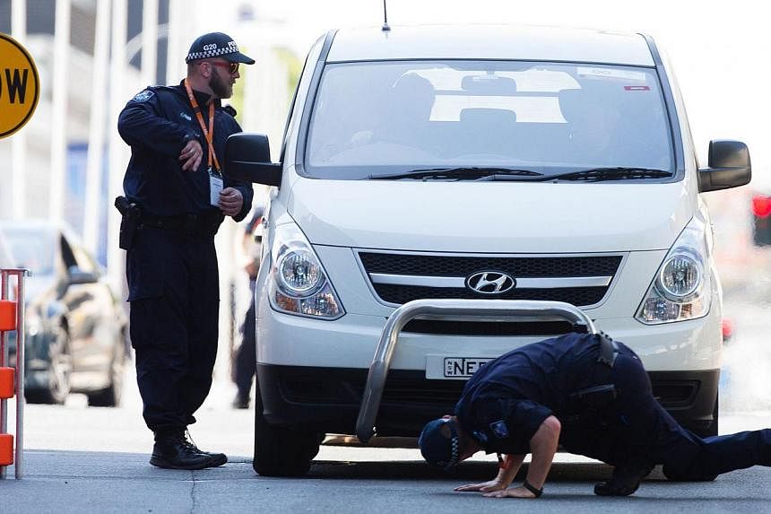 Queensland police check vehicles at an entrance to the G20 Precinct near the Brisbane Exhibition and Convention Centre ahead of the G20 Summit in Brisbane. -- PHOTO: AFP