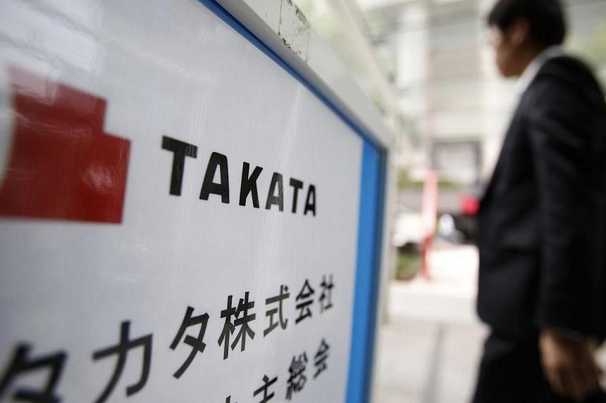 A man walks past a sign board of Japanese auto parts maker Takata Corp's Annual General Meeting in Tokyo in this June 26, 2014 file photograph.&nbsp;Japanese auto parts maker Takata on Thursday rejected a high-profile report that claimed it had cover