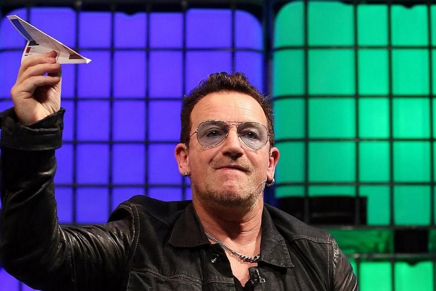 U2 frontman Bono throws a paper aeroplane back into the audience as he speaks on centre stage during the last day of the Web Summit in Dublin, Ireland, on Nov 6, 2014.&nbsp;A private plane carrying U2 frontman Bono lost its rear hatch while approachi