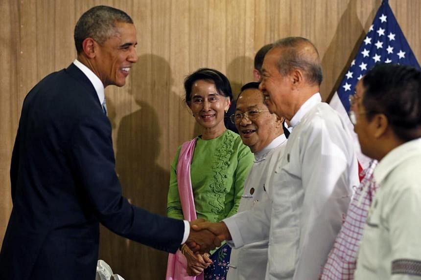 Myanmar opposition leader Aung San Suu Kyi looks on as U.S. President Barack Obama shakes hands after a roundtable with members of parliament and civil society to discuss Myanmar's reform process in Naypyitaw, Myanmar on Nov 13, 2014.&nbsp;US Preside