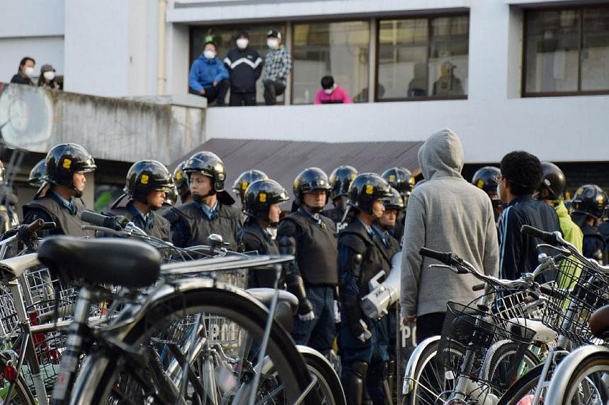 Fully clad riot police raid a dormitory at the Kyoto University in Kyoto, western Japan on Nov 13, 2014 as plain clothed police search the domitory, in an apparently heavy-handed response to a left-wing movement that may involve students.&nbsp;Scores