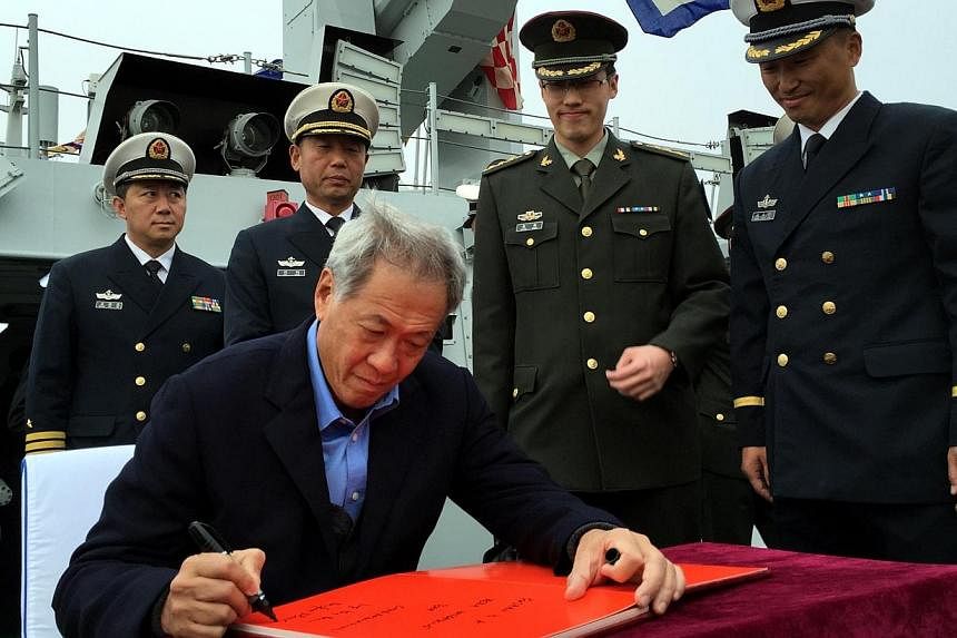 Singapore Defence Minister Ng Eng Hen signing the guest book on the Chinese navy’s newest missile corvette Fushun on Nov 11, 2014.&nbsp;Bigger and more regular joint war games are on the cards, under Singapore's plan to boost its military ties with