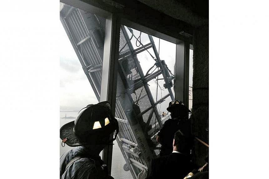 A picture tweeted by the New York City Fire Department appears to show workers trapped on scaffolding outside 1 World Trade Center in New York on Nov 12, 2014. -- PHOTO: REUTERS