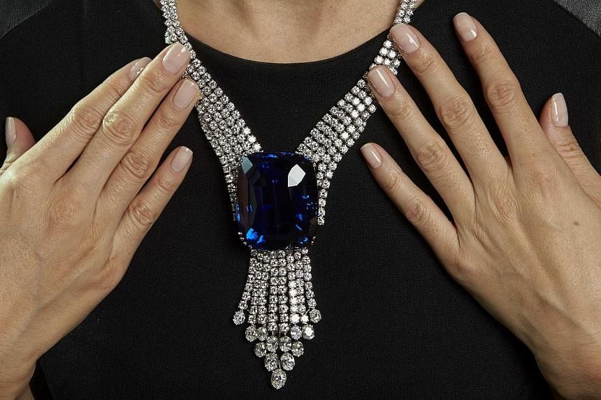 A Christie's staff member wears the Blue Belle of Asia, a 392.52-carat sapphire, during an auction preview in Geneva on Nov 6, 2014. -- PHOTO: REUTERS