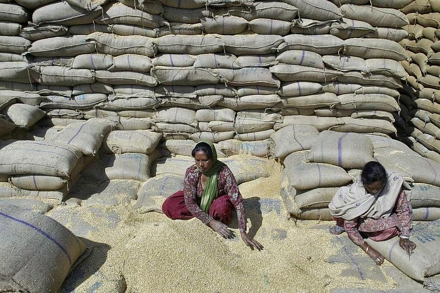 Female labourers collect wheat at a warehouse of Punjab State Civil Supplies Corporation Limited on the outskirts of the northern Indian city of Amritsar in this March 14, 2013 file photo.&nbsp;Washington and New Delhi said Thursday they have resolve