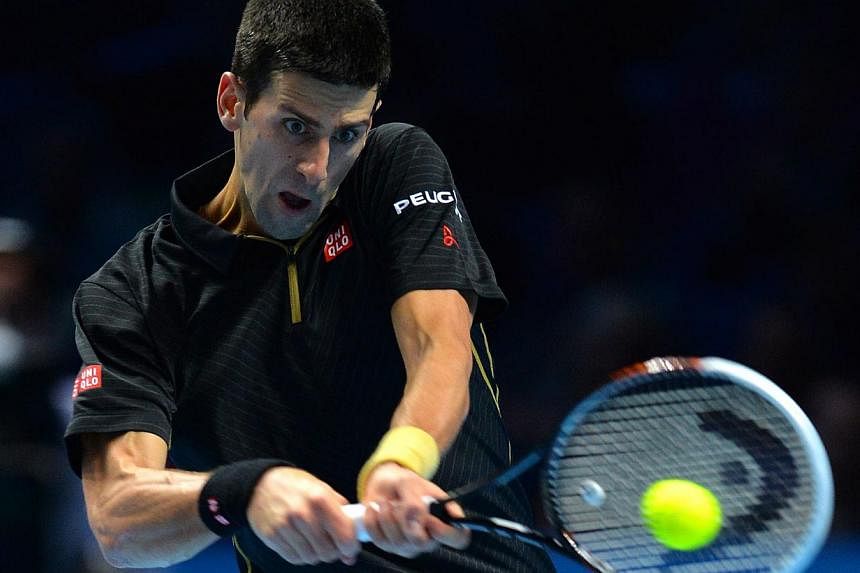 Novak Djokovic of Serbia returns the ball to Stan Wawrinka of Switzerland during their tennis match at the ATP World Tour finals at the O2 Arena in London on Nov 12, 2014. -- PHOTO: REUTERS