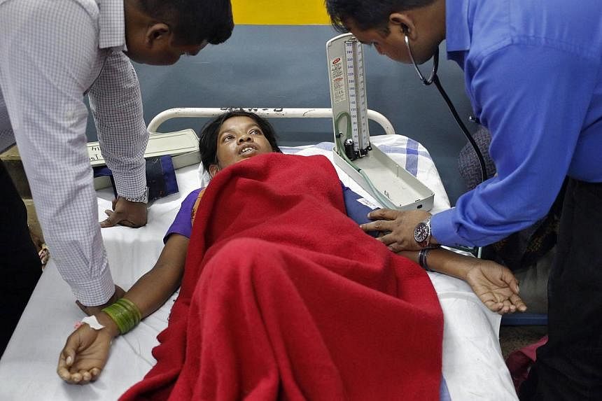Doctors tend to a woman, who underwent a sterilization surgery at a government mass sterilisation "camp", at Chhattisgarh Institute of Medical Sciences (CIMS) hospital in Bilaspur district, in the eastern Indian state of Chhattisgarh, on Nov 13, 2014