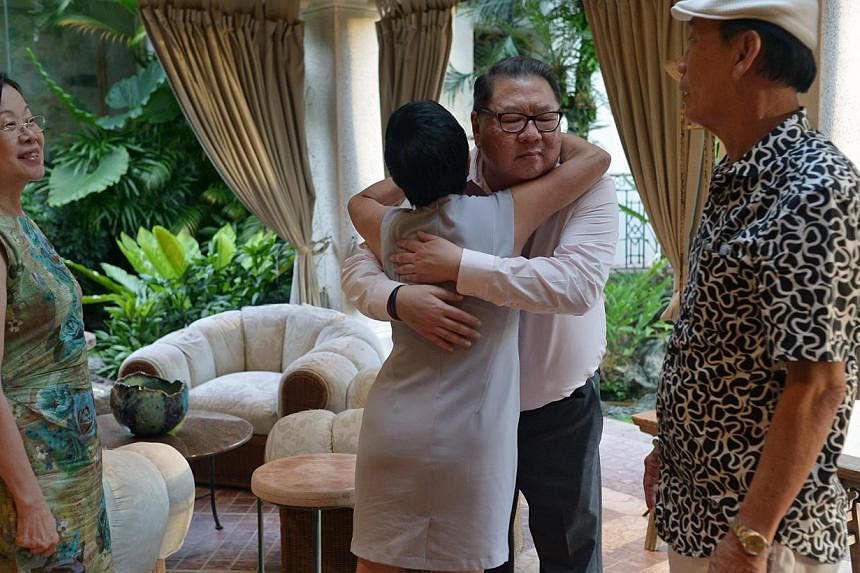 Ms Lucy Lee gives Mr Tang Wee Sung, chairman of Tangs, a hug before leaving his home. With them are, Ms Dinah Tan (left) and Mr Charlie Ong (right). -- ST PHOTO: CAROLINE CHIA