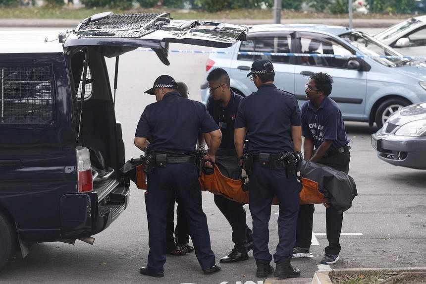 Police removing a body that was found next to a white van with shattered glass on the door of the driver's side at Sembawang Park on Nov 14, 2014. -- ST PHOTO: KEVIN LIM