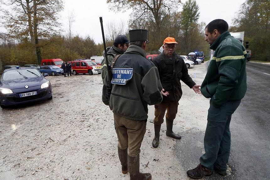 Members of the National Hunting and Wildlife Office talk on Nov 14, 2014 in the woods of Ferrieres-en-Brie, on the outskirts of Paris, during the ongoing search for what was first described as a tiger on the loose. French authorities said on Nov 14 t