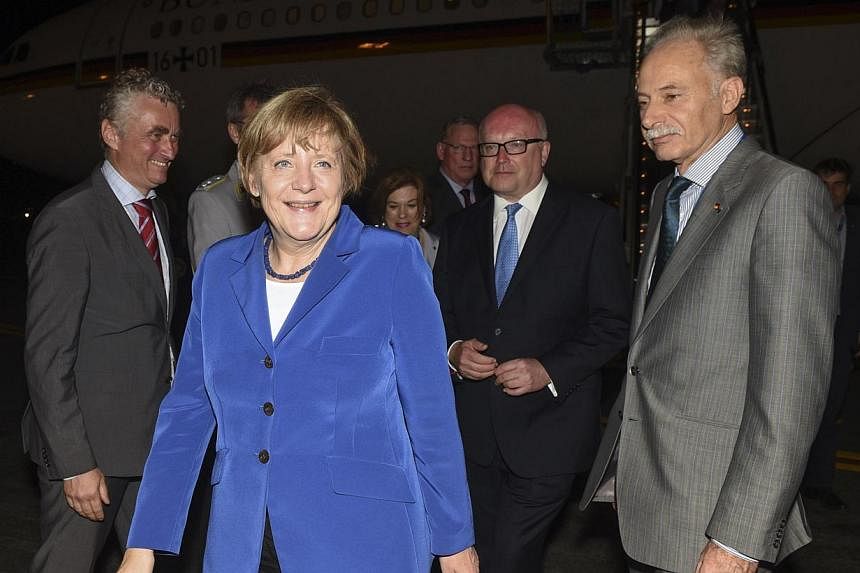 Germany's Chancellor Angela Merkel (second left) smiles after meeting dignitaries upon her arrival at the G20 Terminal in Brisbane on Nov 14, 2014 picture provided by G20 Australia. -- PHOTO: REUTERS