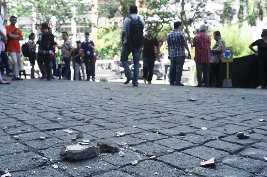 Concrete fragments are seen outside a building as Manado city residents evacuate onto a street after a 7.3-magnitude earthquake shook the capital of Northern Sulawesi island&nbsp;on Nov 15, 2014. -- PHOTO: AFP