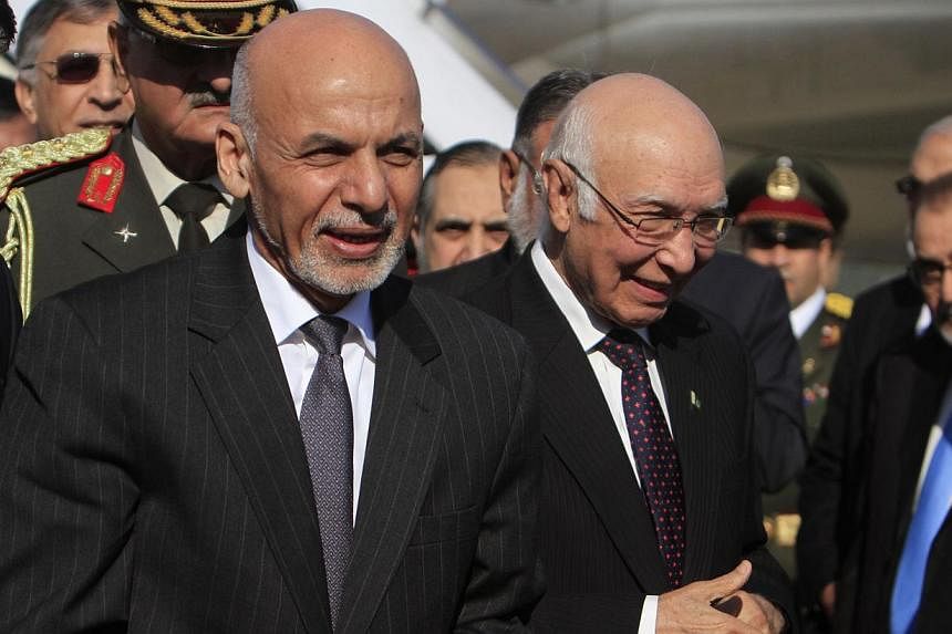 Afghan President Ashraf Ghani (left) walks with Sartaj Aziz, adviser on foreign affairs to Pakistan Prime Minister Nawaz Sharif, after arriving at Chaklala Airbase in Rawalpindi near Islamabad Nov 14, 2014. Ghani arrived in Islamabad on a two day off