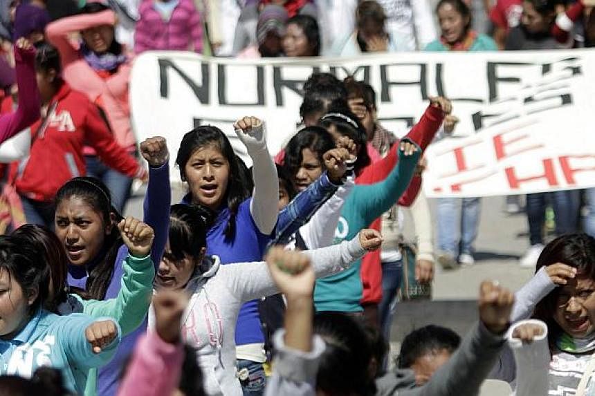 People take part in a protest to demand the safe return of 43 students who went missing in southern Mexico, after an attack by gang-linked police last Sept 26, in Chilpancingo, Guerrero state, Mexico on Nov 14, 2014. -- PHOTO: AFP