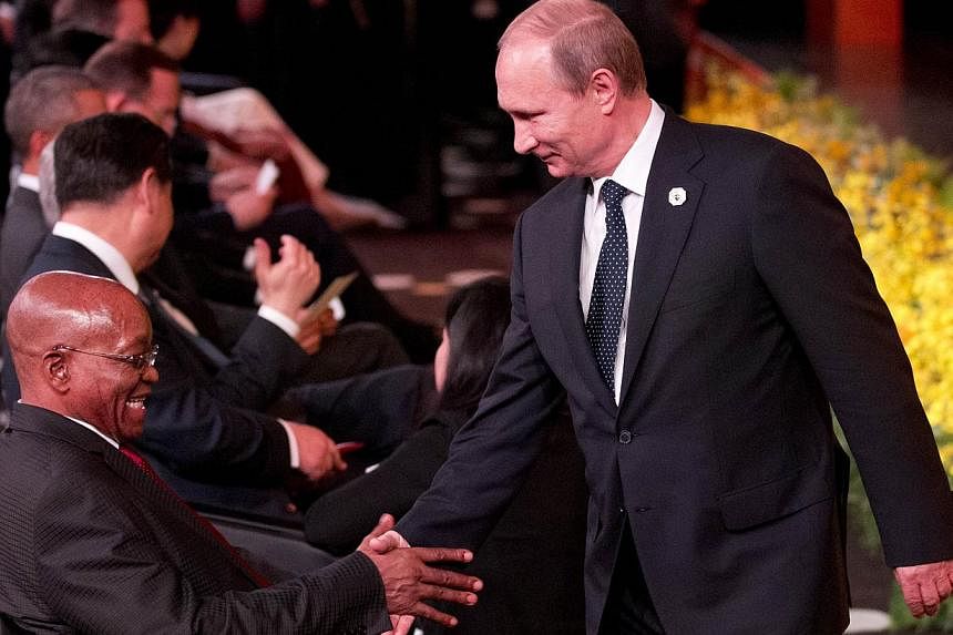 Russian President Vladimir Putin shakes hands with South African President Jacob Zuma at the G-20 Summit in Brisbane on Nov 15, 2014.&nbsp;Russia does not intend to demand early repayment of US$3 billion (S$3.9 billion) which it lent to Ukraine last 
