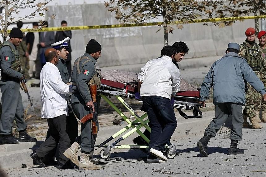 Officials carry a dead body on a stretcher at the site of a blast in Kabul on Nov 16, 2014. Shukria Barakzai, an outspoken Afghan female lawmaker, survived a suicide attack on her vehicle on Sunday but three civilian bystanders were killed, a police 