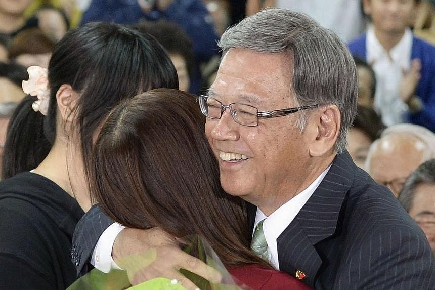Former Naha mayor Takeshi Onaga, (right) hugs his daughter as they celebrate his victory in the Okinawa gubernatorial election in Naha, Okinawa on Nov 16, 2014.&nbsp;The election of Mr Onaga, who opposes plans to relocate a US military base within th