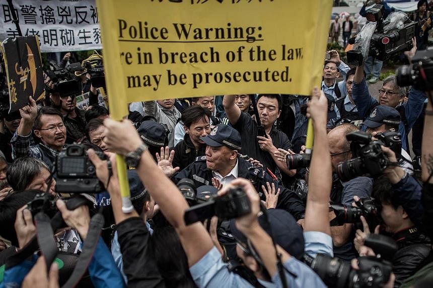 Demonstrators march towards the police headquarters, a day after the arrest of volunteer marshalls at a protest site, in the Admiralty district of Hong Kong on Nov 13, 2014.&nbsp;A Hong Kong court notice ordering the eviction of democracy demonstrato