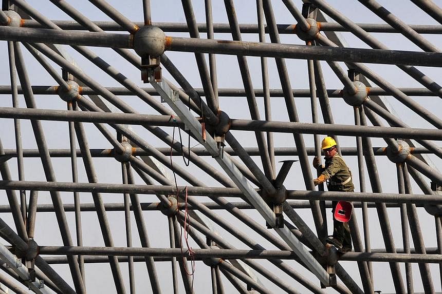 A worker welds steel bars during construction of the roof of a new railway station in Urumqi, Xinjiang Uighur Autonomous region on Oct 12, 2014.&nbsp;China opened the first stretch of a new high-speed railway in the western region of Xinjiang on Sund