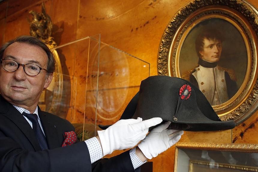 Auctioneer Jean-Pierre Osenat displays a black felt two-cornered hat belonging to French Emperor Napoleon Bonaparte at their auction house in Paris on Oct 24, 2014.&nbsp;-- PHOTO: REUTERS