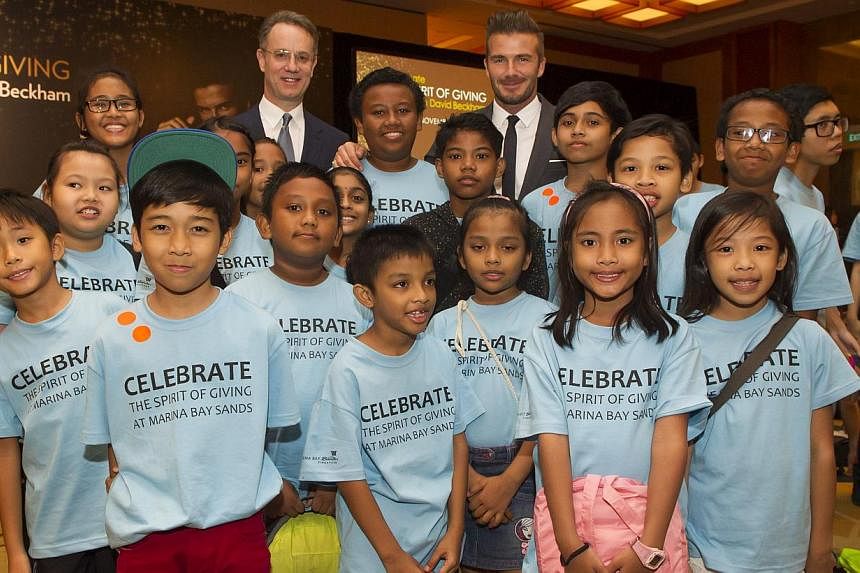 Mr. George Tanasijevich, President and Chief Executive Officer of Marina Bay Sands and David Beckham with Sands for Singapore beneficiaries. -- &nbsp;PHOTO: MARINA BAY SANDS