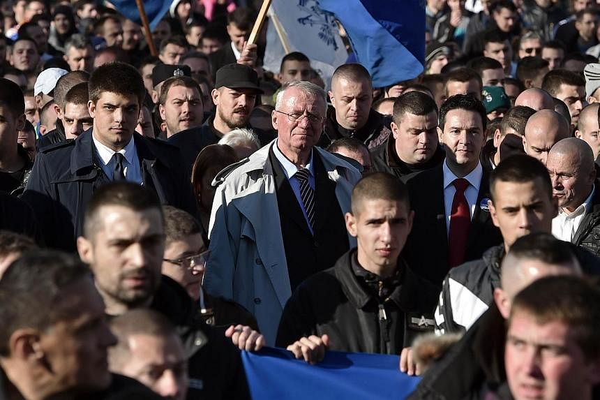 Serbian nationalist politician Vojislav Seselj walks among supporters during an anti-government rally in Belgrade on Nov 15, 2014.&nbsp;Some 10,000 supporters of the Serb ultranationalist Seselj, released by a UN war crimes court for cancer therapy, 