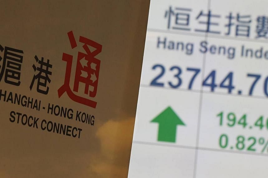 A banner introducing the Shanghai-Hong Kong Stock Connect is displayed in front of a panel showing the closing blue-chip Hang Seng Index at the Hong Kong Stock Exchange in Hong Kong on Nov 10, 2014. -- PHOTO: REUTERS&nbsp;