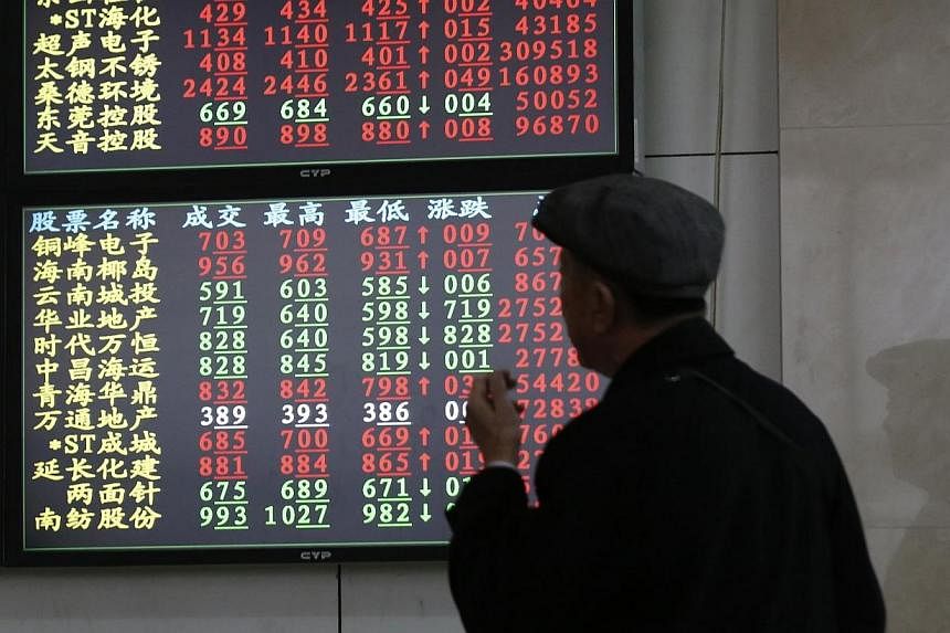 An investor looks at stock informationat a brokerage house in Shanghai on Nov 17, 2014.&nbsp;A daily investment quota for the Shanghai leg of a stock market scheme linking mainland China and Hong Kong exchanges was exhausted in early afternoon tradin