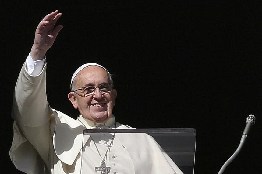 Pope Francis waves during his Sunday Angelus prayer in Saint Peter's Square at the Vatican on Nov 16, 2014. The Pope said on Monday, Nov 17, that he will visit the United States in September 2015 to take part in a Catholic Church congress on the fami
