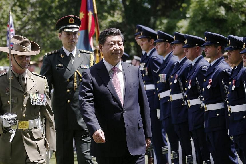 China's President Xi Jinping (centre) inspects an honour guard at Government House in Canberra on Nov 17, 2014. -- PHOTO: REUTERS