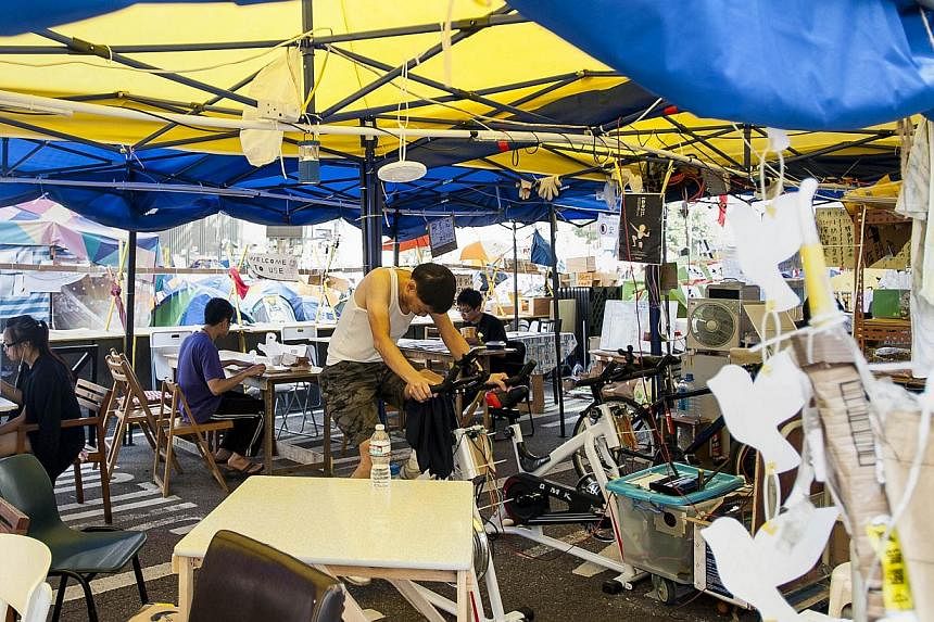 A man does exercise on a static bike inside the Occupy Camp set up by pro-democracy protesters in the Admiralty area of Hong Kong on Nov 17, 2014.&nbsp;-- PHOTO: AFP