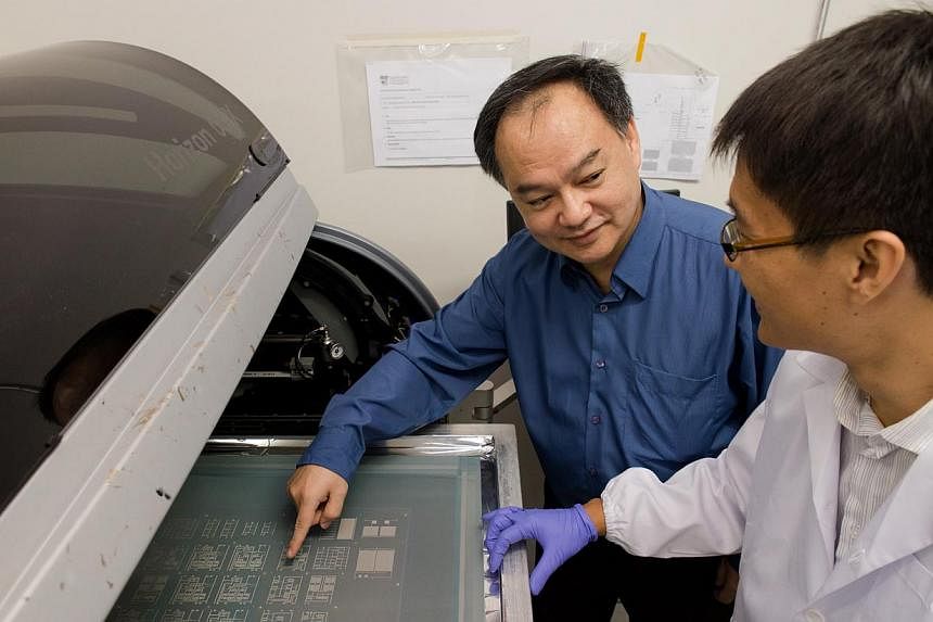 Assoc Prof Joseph Chang (left) with PhD student Zhou Jia, who is using a t-shirt printer to print flexible electronic circuits.&nbsp;-- PHOTO:&nbsp;NANYANG TECHNOLOGICAL UNIVERSITY