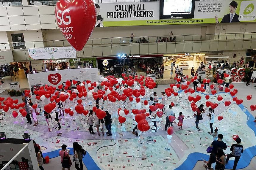 People marking the locations of places significant to them on a Singapore map using heart-shaped balloons at the HDB Hub Mall yesterday.