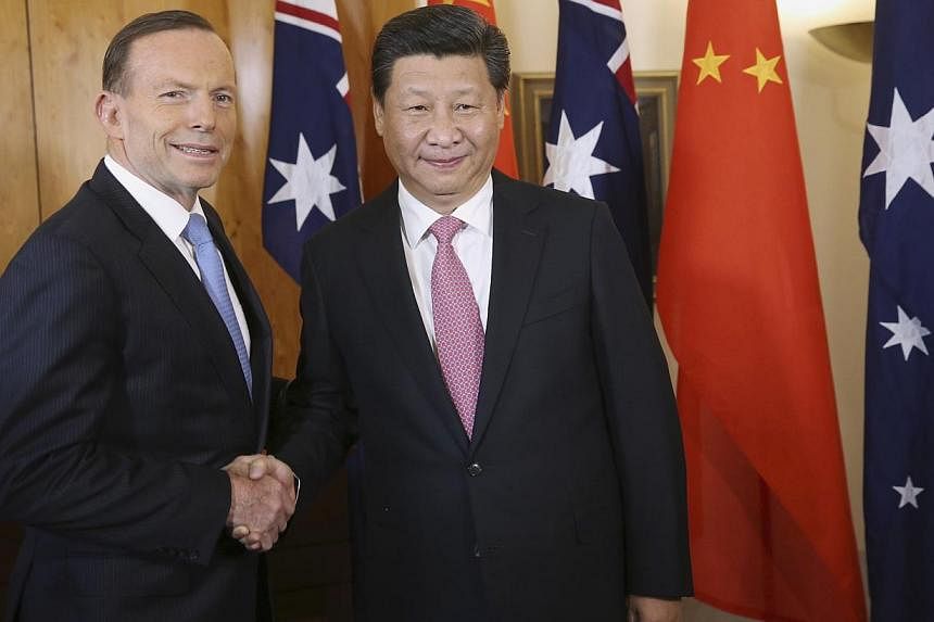 China's President Xi Jinping (right) shakes hands with Australia's Prime Minister Tony Abbott in Canberra on Nov 17, 2014. Prime Minister Tony Abbott confirmed on Monday he had concluded negotiations on a free trade deal with China. -- PHOTO: REUTERS