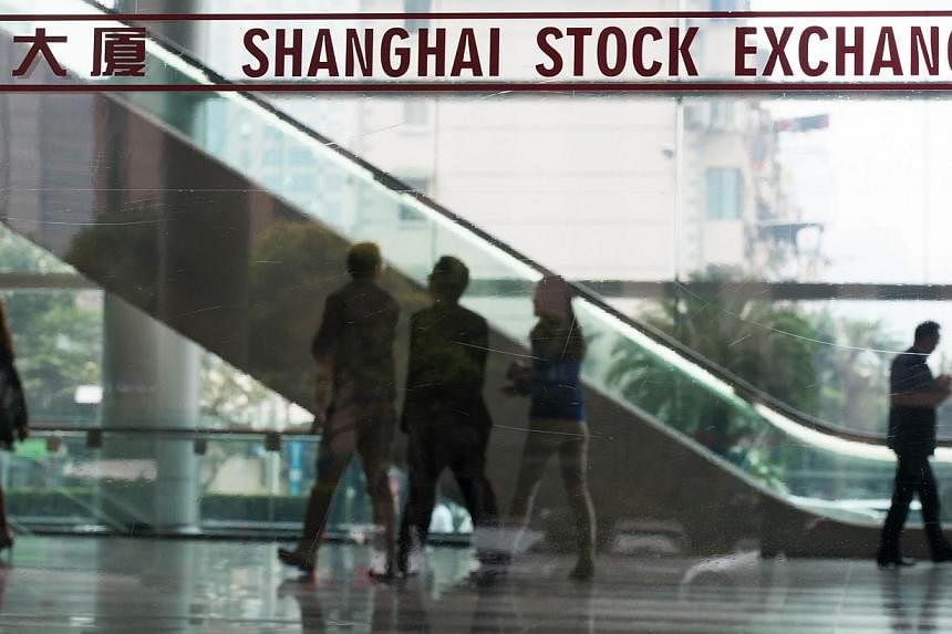 People walking inside the Shanghai Stock Exchange building in Shanghai on Oct 16. Chinese and Hong Kong shares jumped as trading opened on Monday as a landmark trading scheme linking the Shanghai and Hong Kong stock exchanges kicked off. --PHOTO: AFP