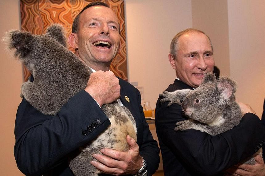 Australia's Prime Minister Tony Abbott (left) and Russia's President Vladimir Putin each hold a koala before the G20 Leaders' Summit in Brisbane on Nov 15, 2014. -- PHOTO: REUTERS