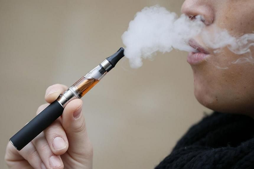 A person smokes an electronic cigarette on March 05, 2013, in Paris.&nbsp;Oxford Dictionaries picked "vape" - the act of smoking an e-cigarette - as their new word of the year on Tuesday, with the affectionate "bae" and the more pragmatic "contactles