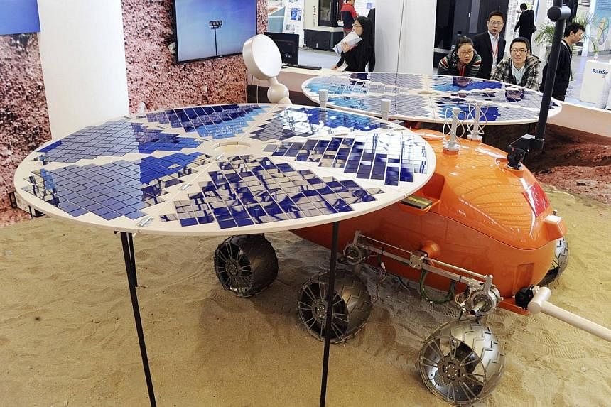 Visitors look at a prototype model of a Mars rover, which was designed and built in China, on display at the China International Industry Fair in Shanghai, on Nov 4, 2014.&nbsp;Chinese scientists are planning to launch a Mars rover "around 2020", sta
