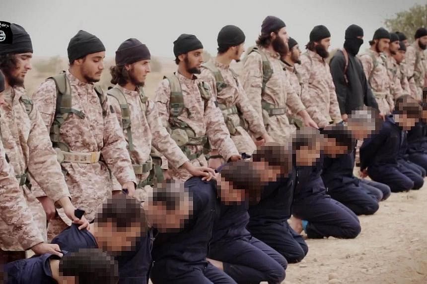 An image grab taken from a propaganda video released on November 16, 2014 by al-Furqan Media allegedly shows members of the Islamic State in Iraq and Syria (ISIS) extremist group preparing the simultaneous beheadings of at least 15 men described as S