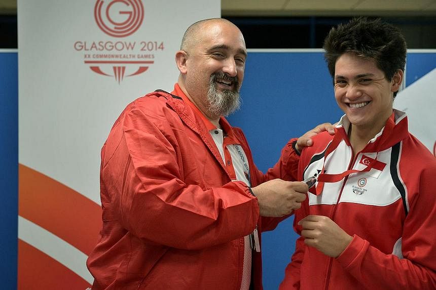 Joseph Schooling (right) celebrating his silver-medal achievement in the 100m butterfly event with his coach Sergio Lopez at the Tollcross International Swimming Centre on July 28, 2014. -- PHOTO: ST FILE