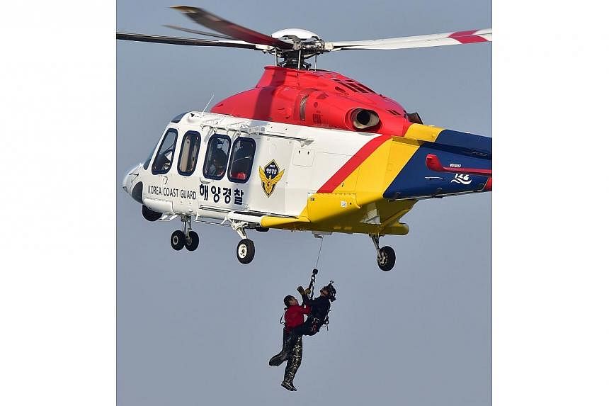 A South Korean Coast Guard helicopter carrying a mock victim during a ferry rescue operation as part of the Safety Korea Exercise, a nationwide anti-disaster drill, off the western port of Incheon on Oct 23, 2014. A massive new government agency to r