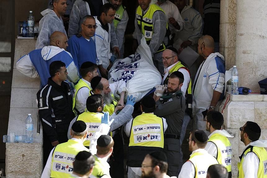 Israeli emergency personnel carry the body of a victim from the scene of an attack at a Jerusalem synagogue on Nov 18, 2014. Pope Francis has condemned the attack and expressed concern about rising tension and violence in the city. -- PHOTO: REUTERS