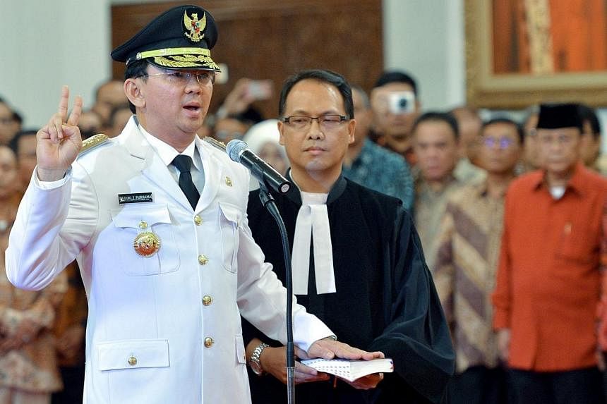 Jakarta's new governor Basuki Tjahaja Purnama (left), also known as Ahok, being sworn in during a ceremony at the Palace in Jakarta on Nov 19, 2014.&nbsp;Jakarta's first Christian governor in nearly 50 years was sworn in on Wednesday in the face of p