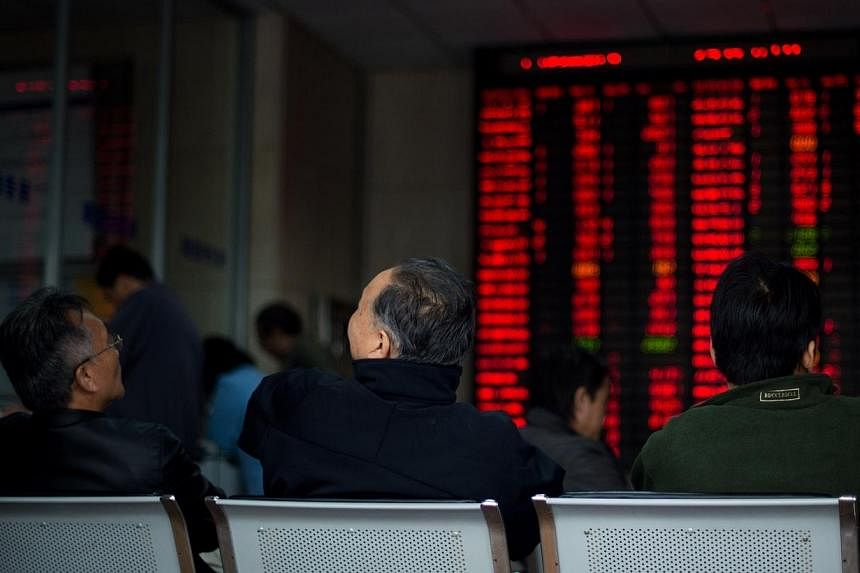 Investors look at a screen showing stock information at a brokerage house in Shanghai on Nov 17, 2014.&nbsp;Foreign buyers used only 20 per cent of their 13 billion yuan (S$2.76 billion) daily quota of Shanghai stocks on Wednesday, Nov 19, as demand 